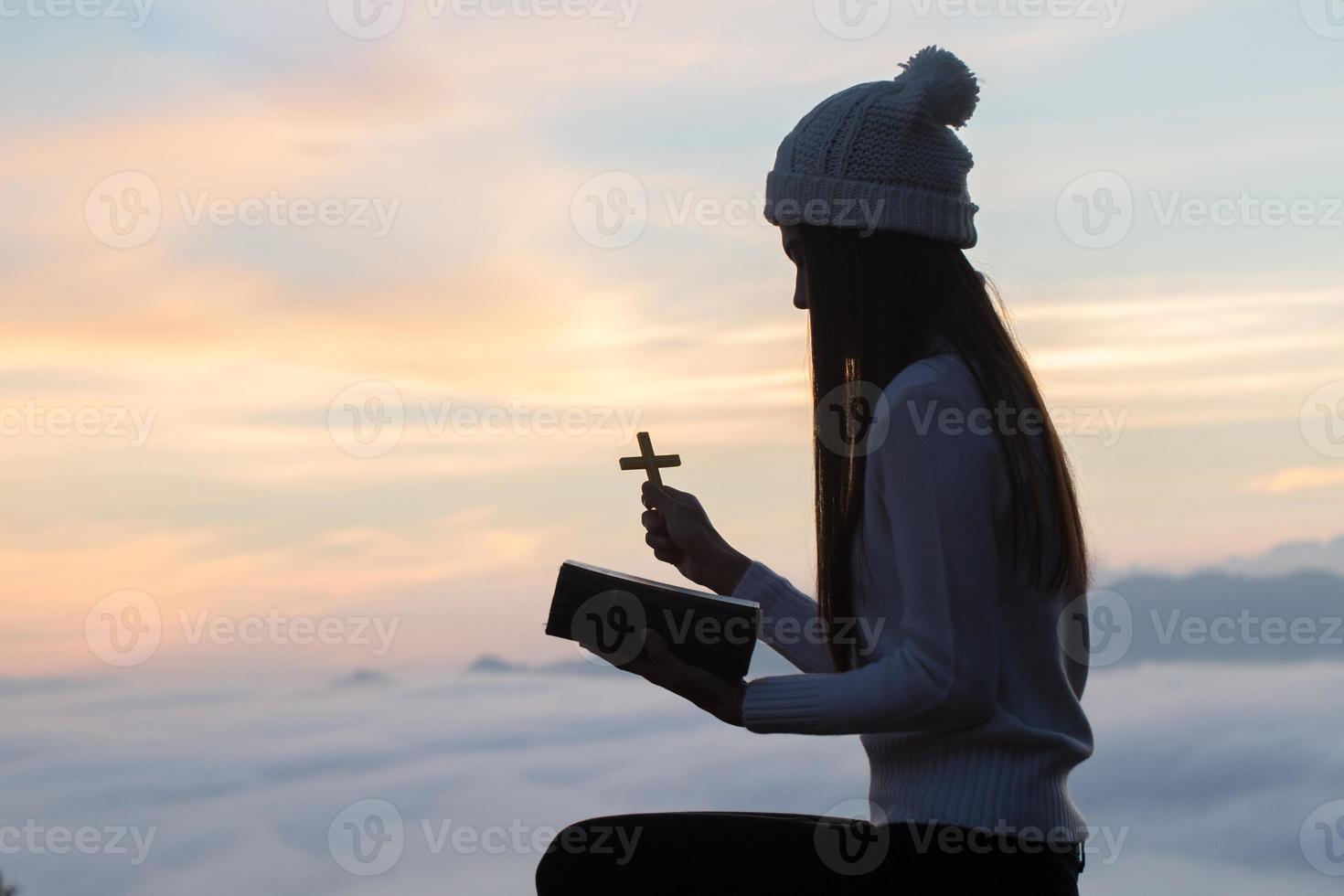 le donne pregano Dio con la Bibbia e la croce del mattino. la donna prega per la benedizione di Dio di desiderare una vita migliore. preghiera di crisi della vita cristiana a dio. foto
