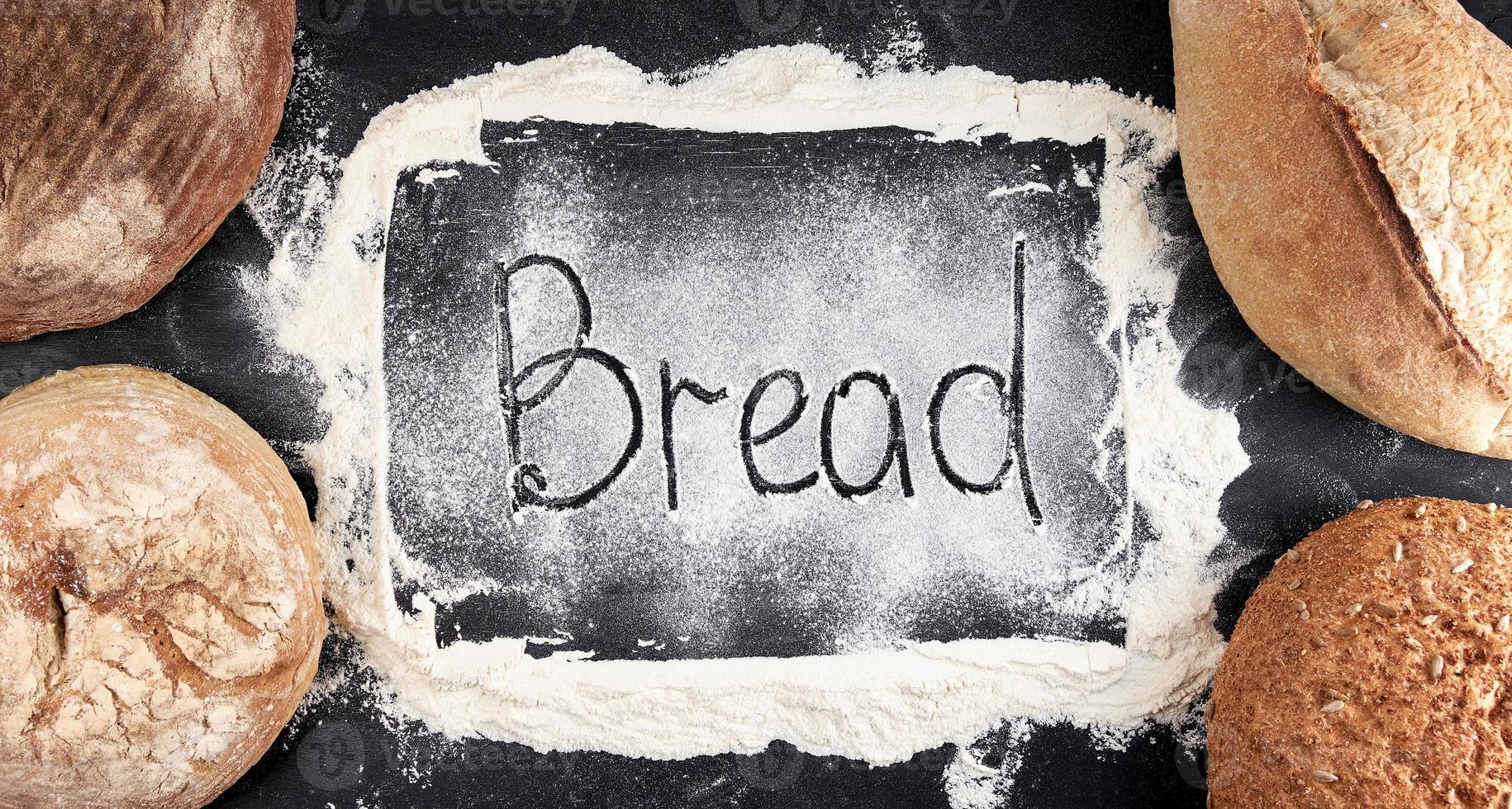 iscrizione pane su bianca Grano Farina sparpagliato, nel il angolo menzogna il giro al forno pagnotte di pane foto