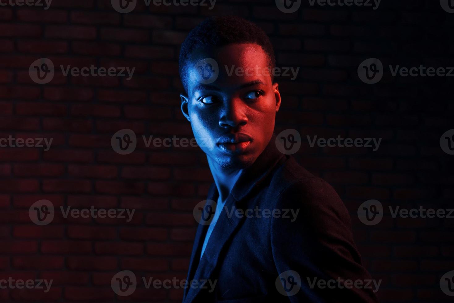 futuristico neon illuminazione. giovane africano americano uomo nel il studio foto