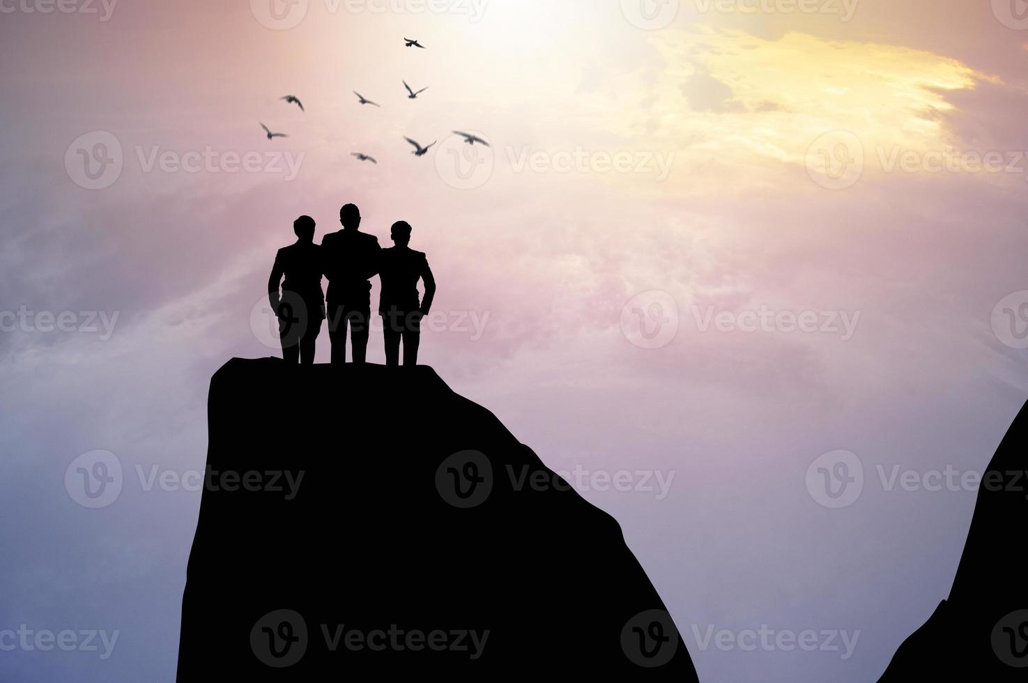 tre persone in piedi su una scogliera foto