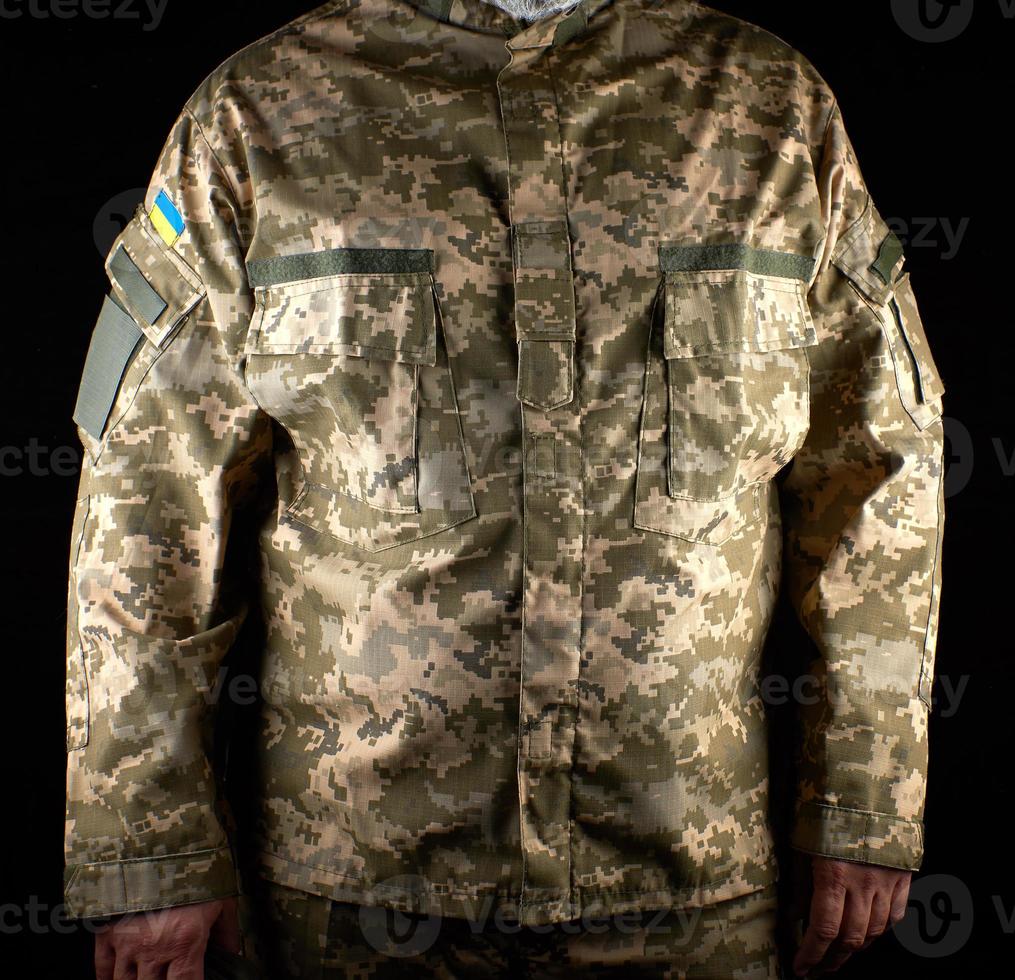 ucraino soldato vestito nel uniforme sta nel il buio foto
