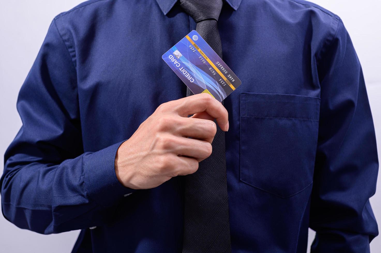 uomo che tiene carta di credito blu foto