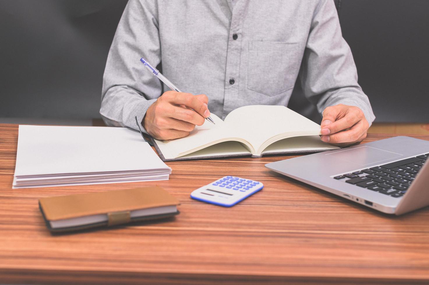 persona che scrive in un libro foto