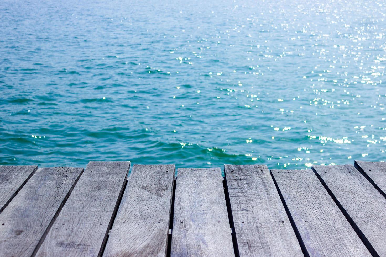 piano del tavolo in legno per la visualizzazione con acqua blu per lo sfondo foto