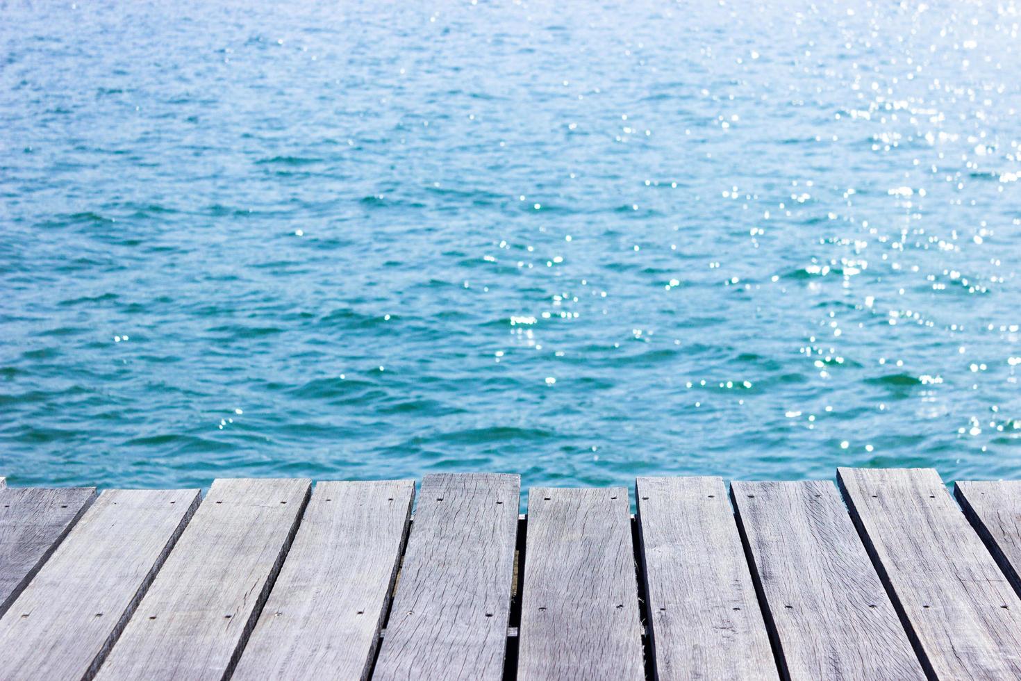 piano del tavolo in legno per la visualizzazione con acqua blu per lo sfondo foto