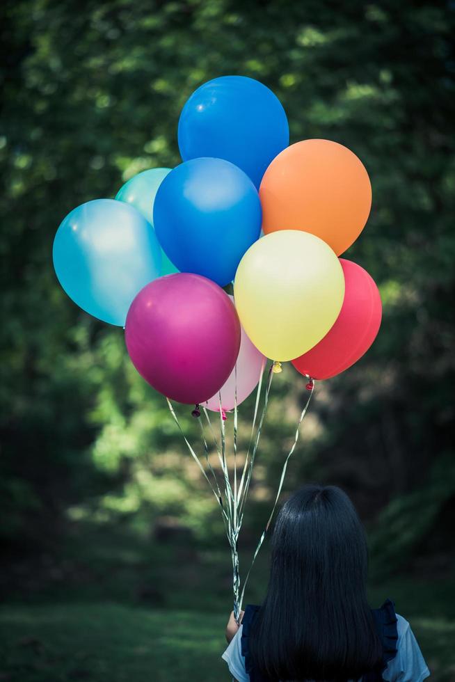 giovane ragazza con palloncini colorati in natura foto