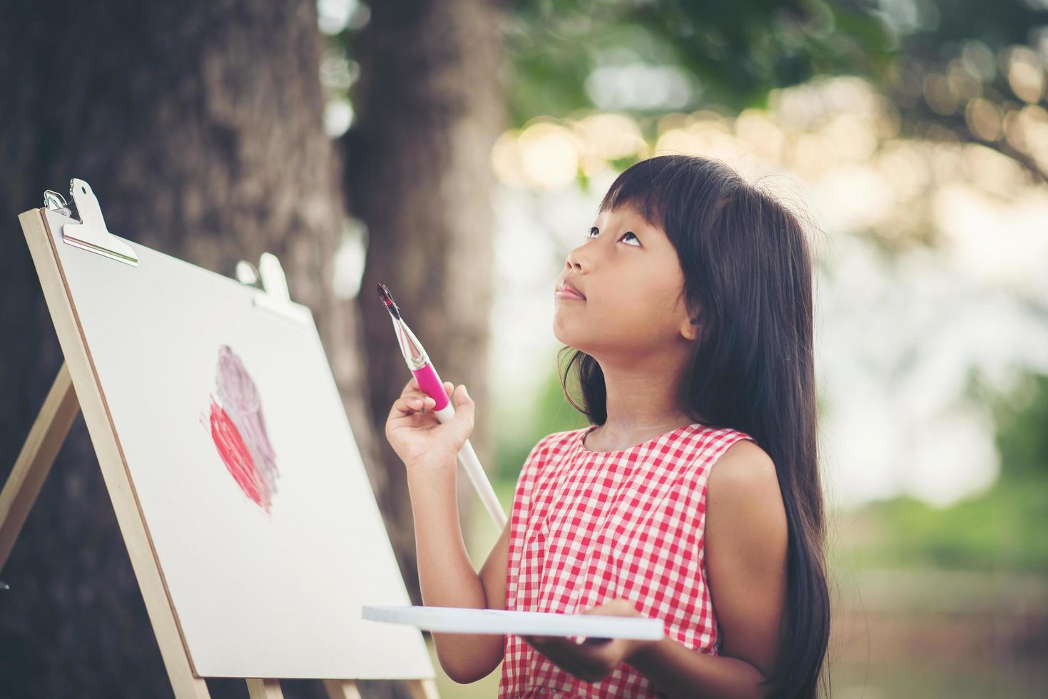 artista della bambina che dipinge un quadro nel parco foto