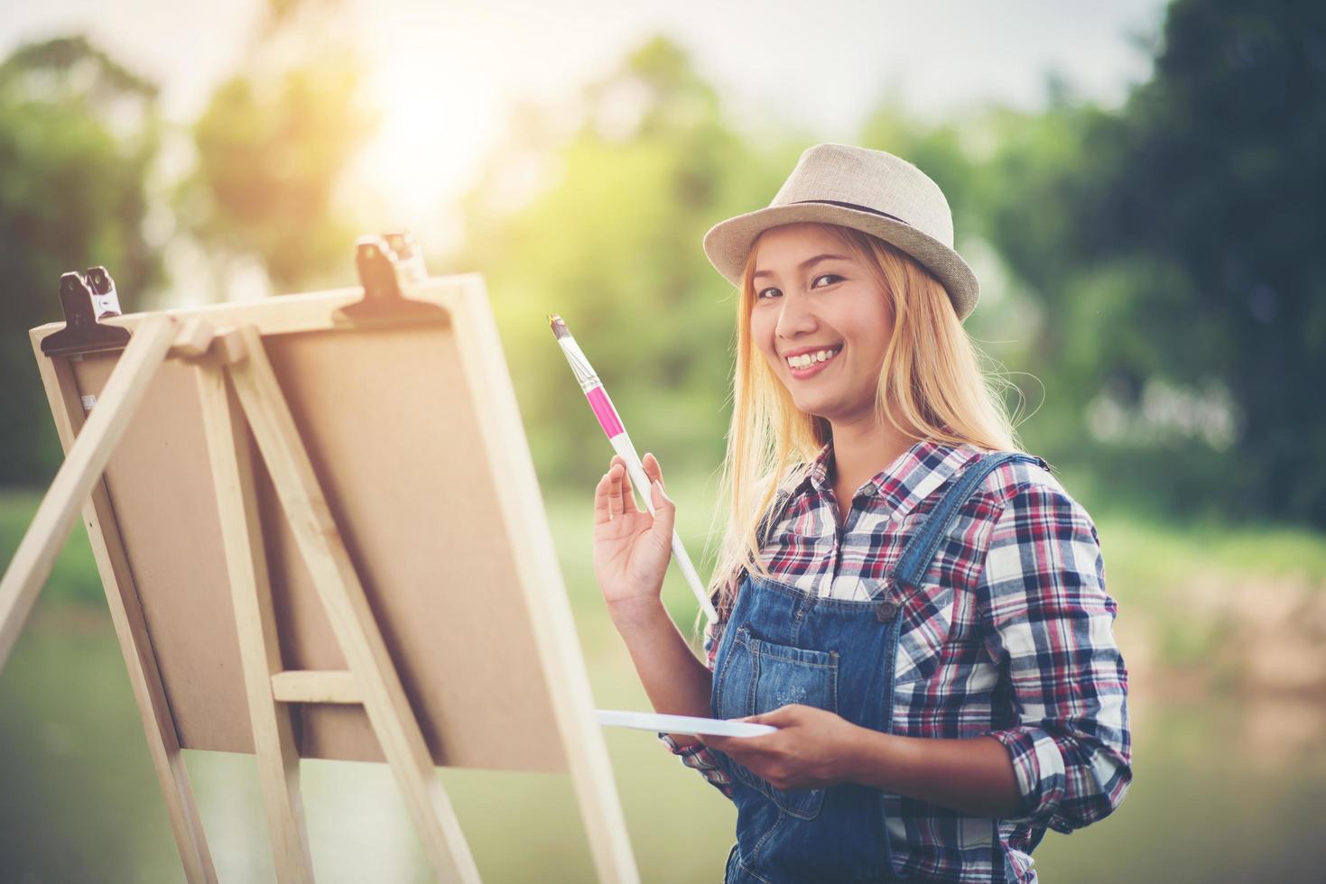 la giovane donna disegna un'immagine nel parco foto