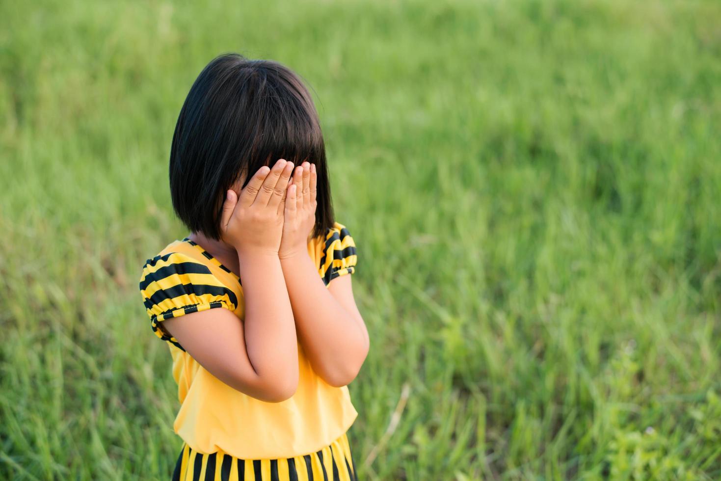 piccola ragazza che copre il viso foto