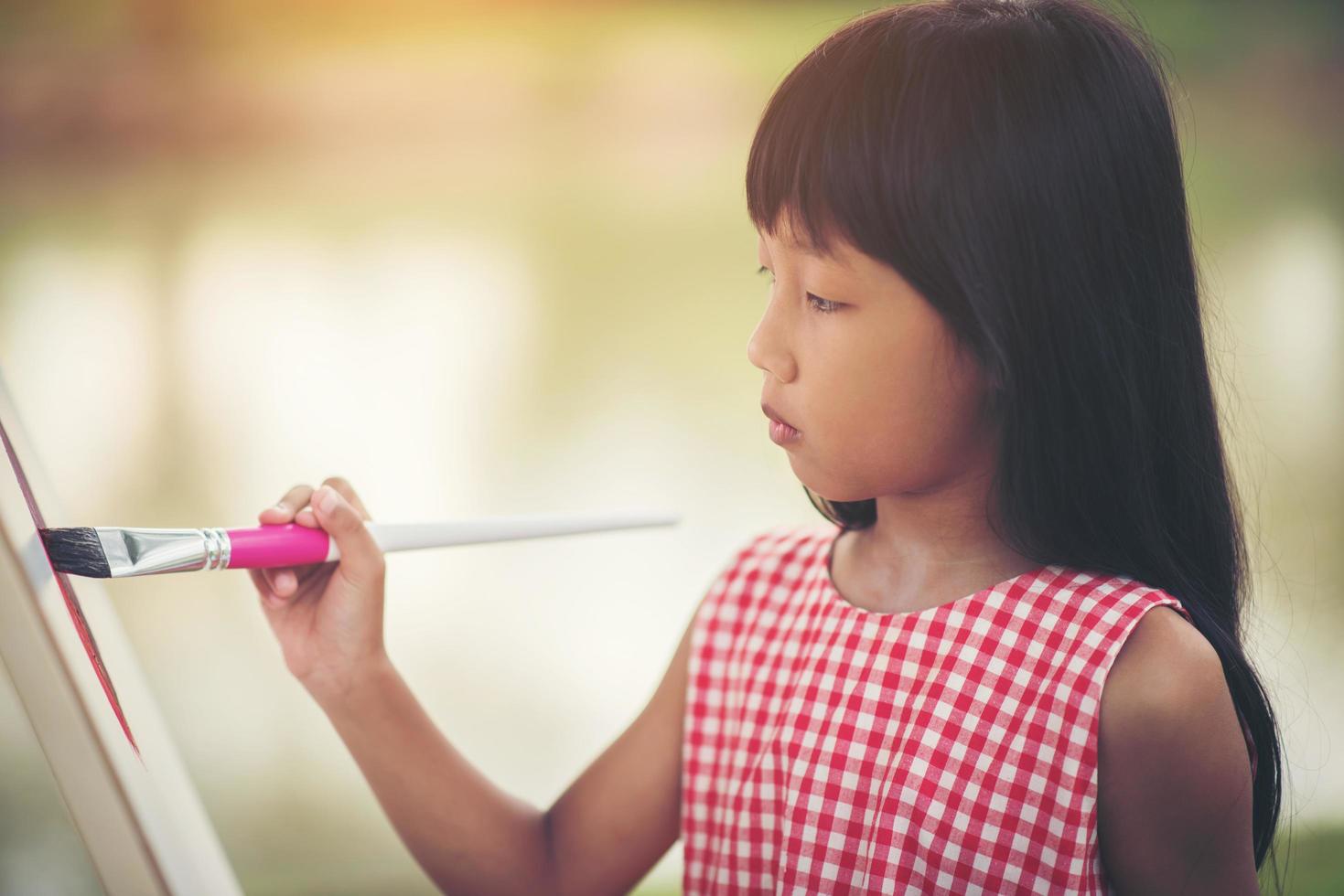 artista della bambina che dipinge un quadro nel parco foto