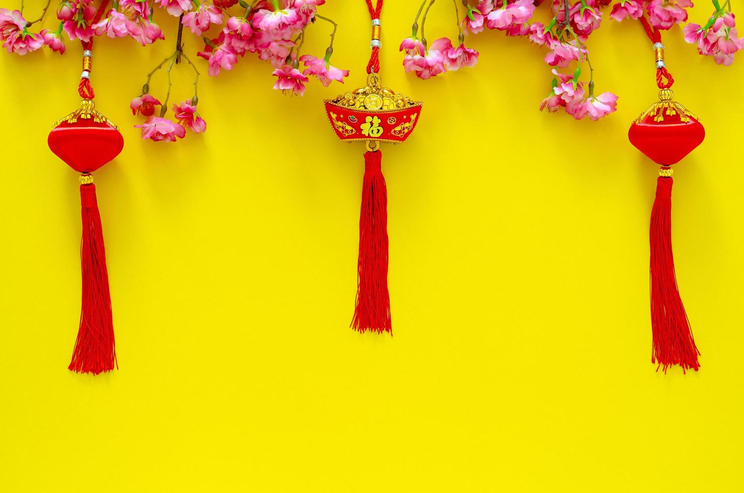 sospeso ciondoli per Cinese nuovo anno ornamento senso di parola è ricchezza con Cinese fiorire fiori su giallo sfondo. foto