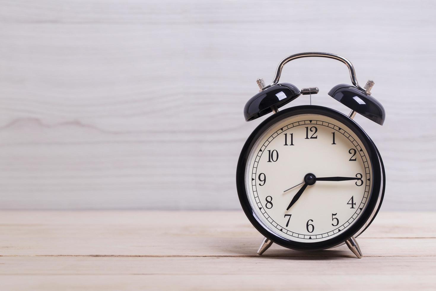 orologio nero sul tavolo di legno foto