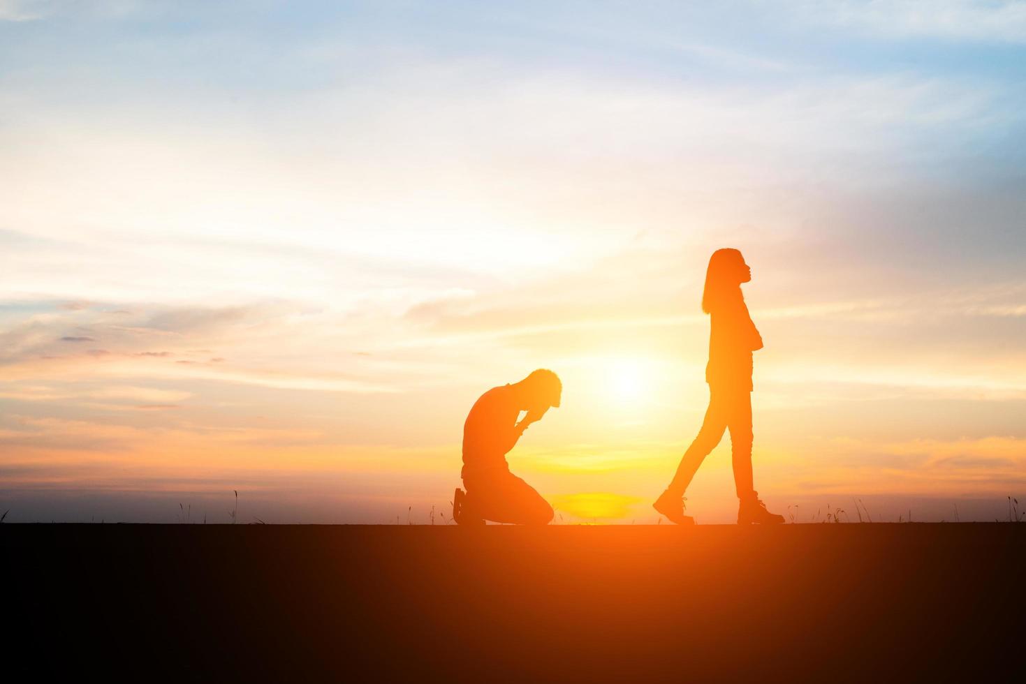 silhouette di una coppia sconvolta in una lite al tramonto foto