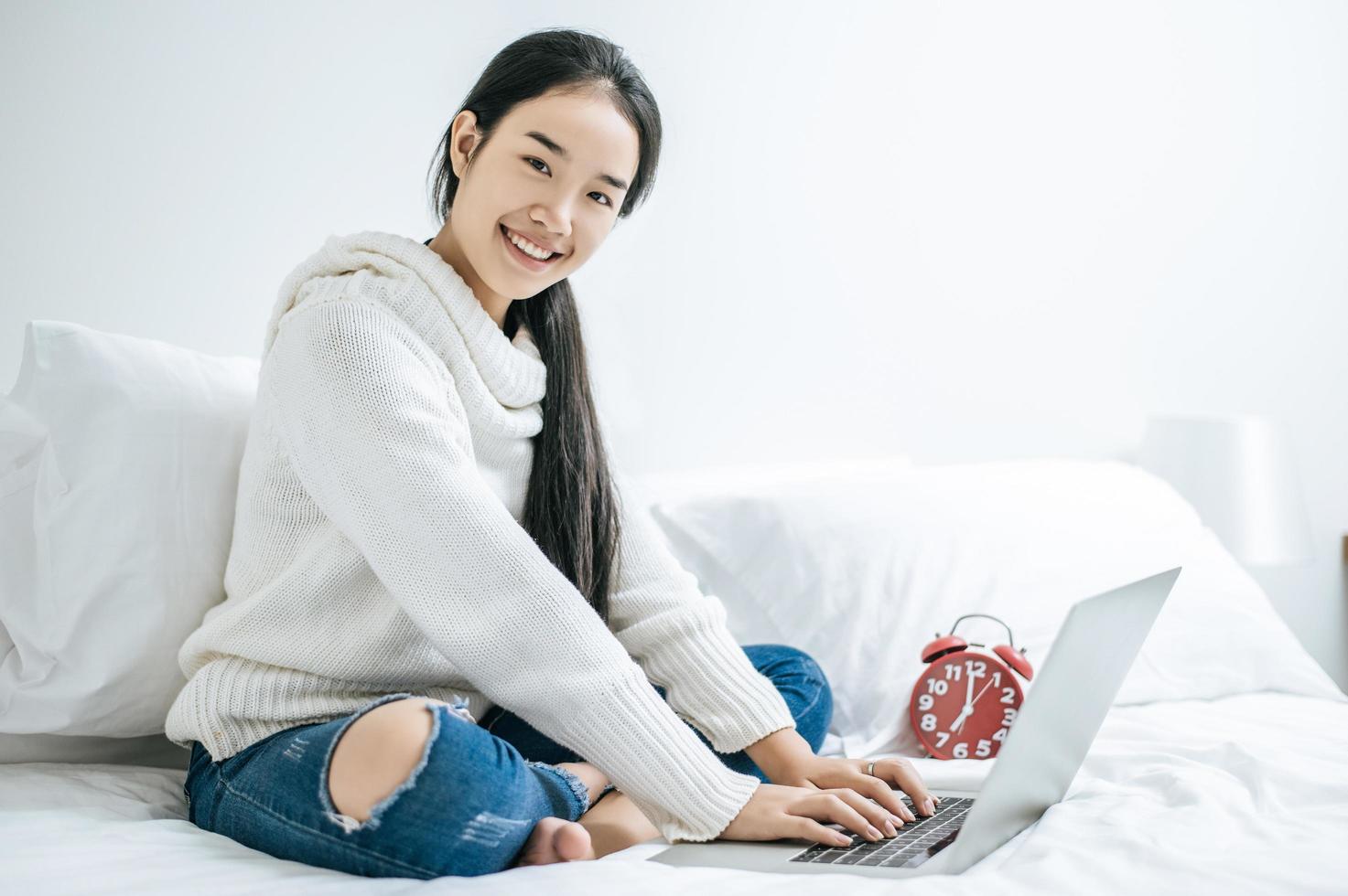 una giovane donna che gioca felicemente sul suo laptop foto