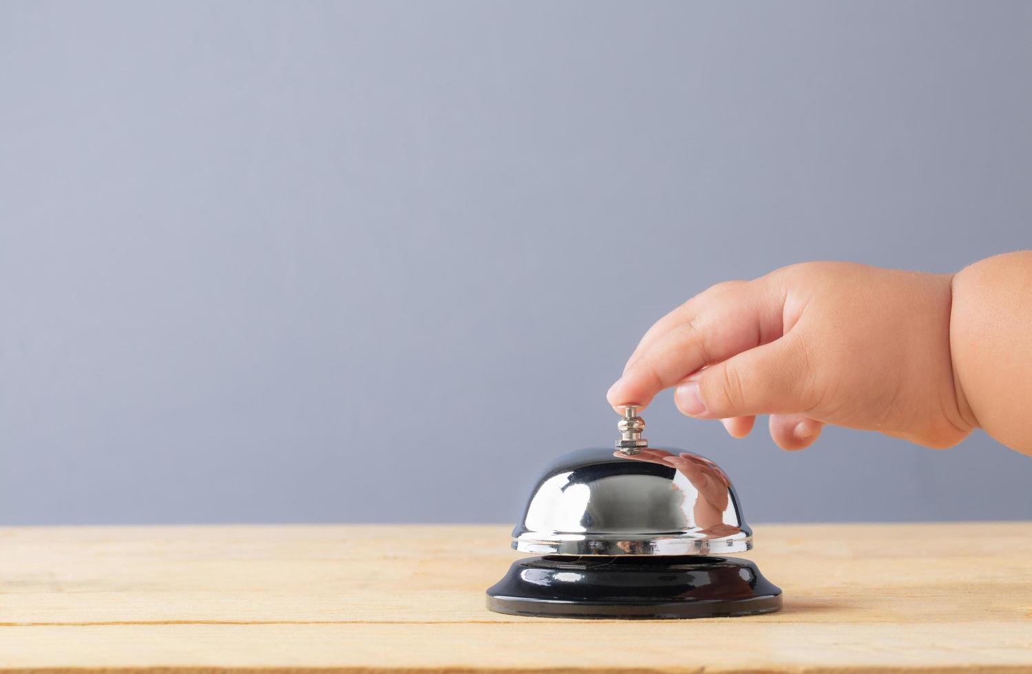 mano del bambino sul campanello di servizio foto