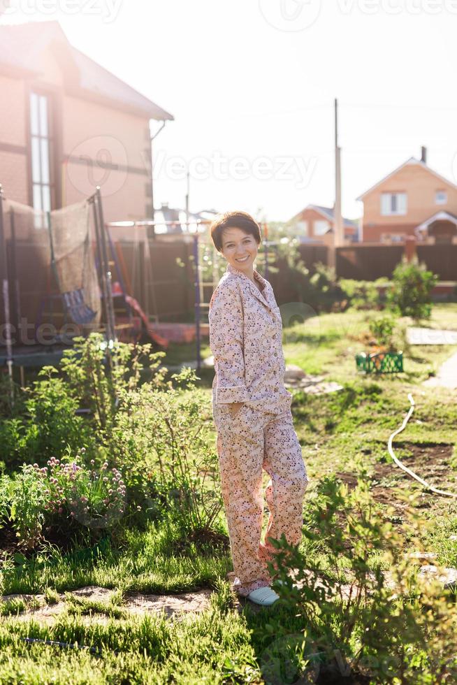 allegro donna nel casa indossare pigiama estate all'aperto Giardino dietro la casa nel casa - biancheria da notte e abbigliamento da casa concetto foto