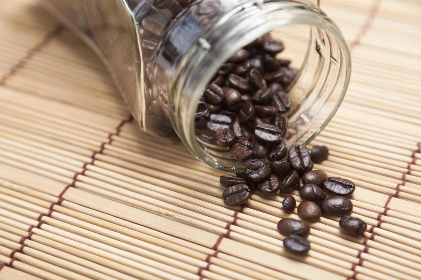 chicchi di caffè fuoriusciti dalla bottiglia foto