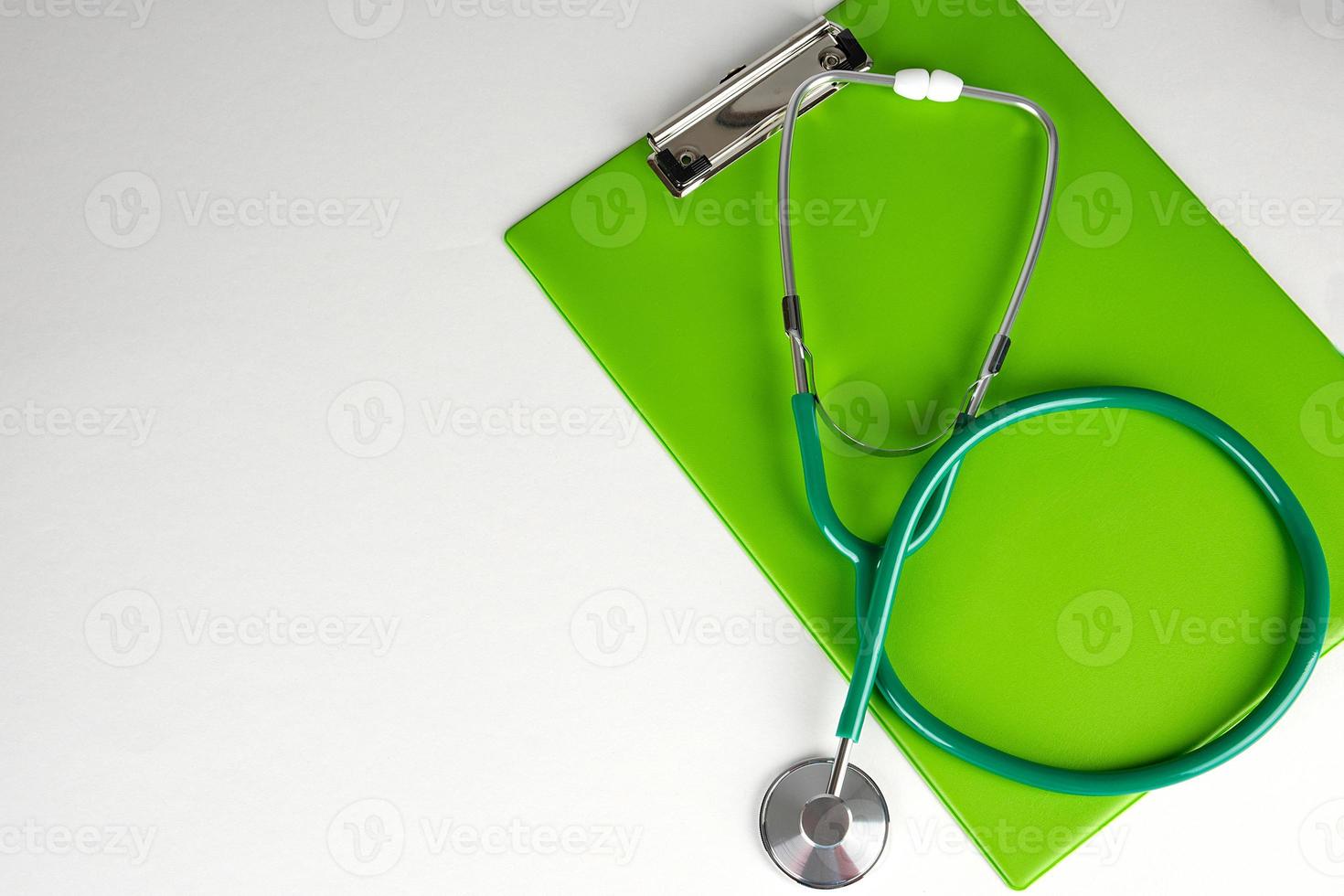 medico stetoscopio e verde carta titolare foto