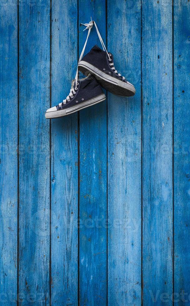 paio blu scarpe da ginnastica su un' di legno parete foto