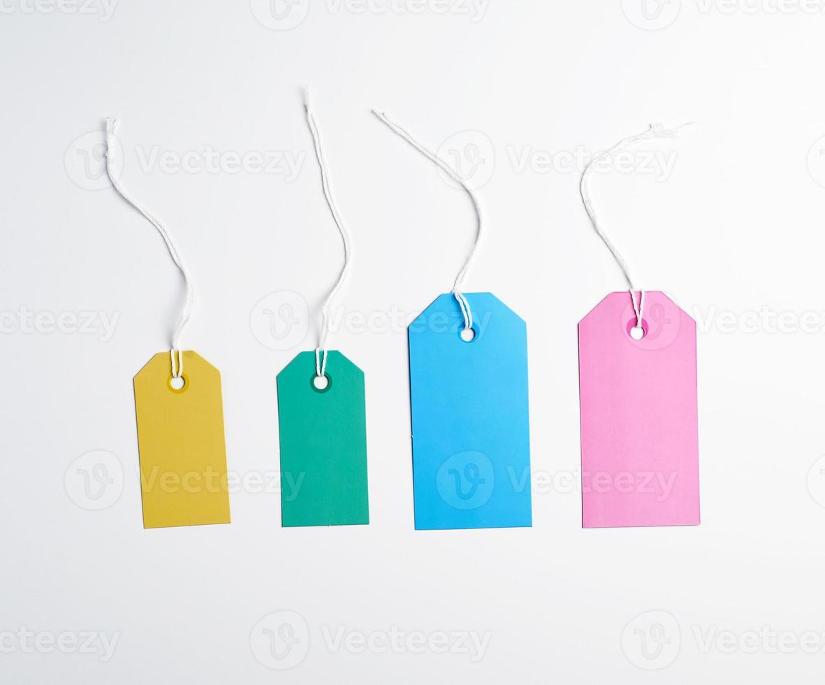 colorato carta tag su un' bianca corda, bianca sfondo foto