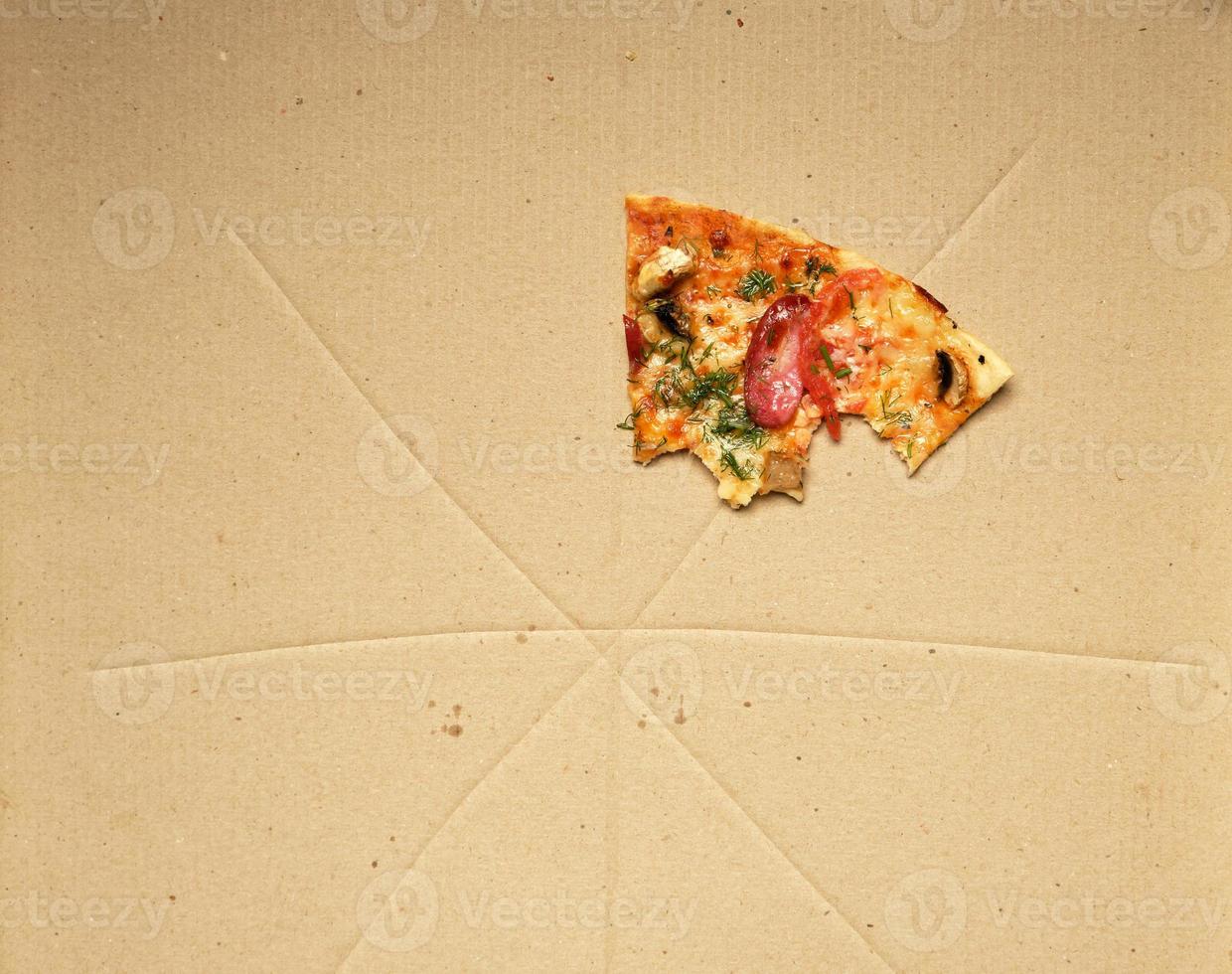 Bitten Pizza con affumicato salsicce, funghi, formaggio e pomodori nel un' Marrone cartone scatola foto