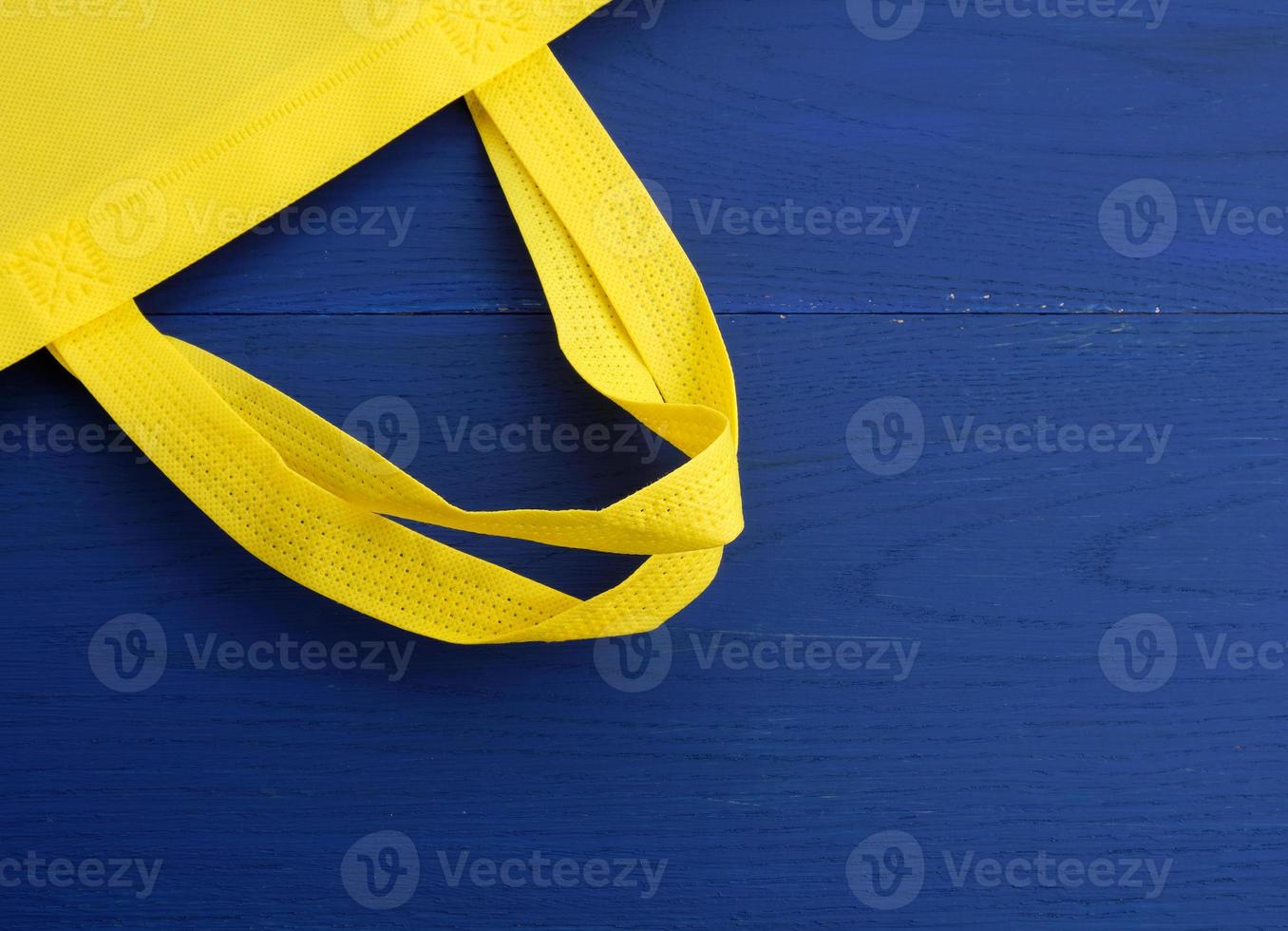 riutilizzabile giallo viscosa Borsa su blu di legno sfondo foto