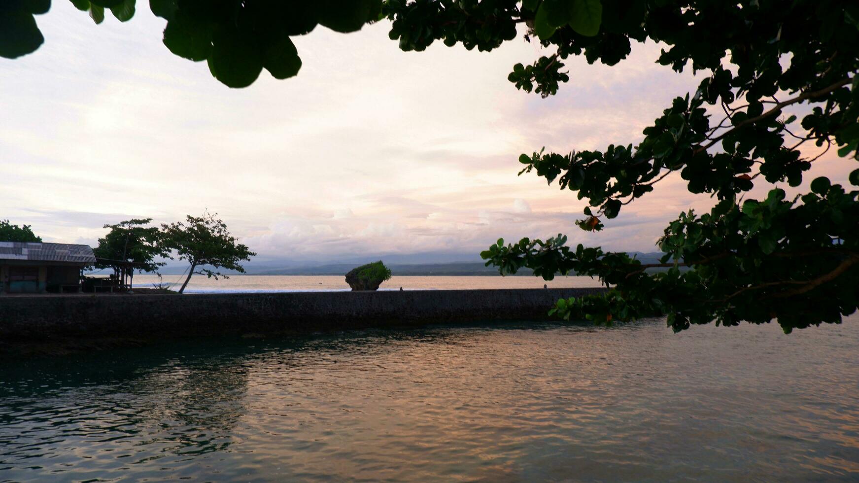 pomeriggio mare Visualizza e diga marina, spiaggia, e corallo, tramonto sfondo su santolo spiaggia Indonesia foto