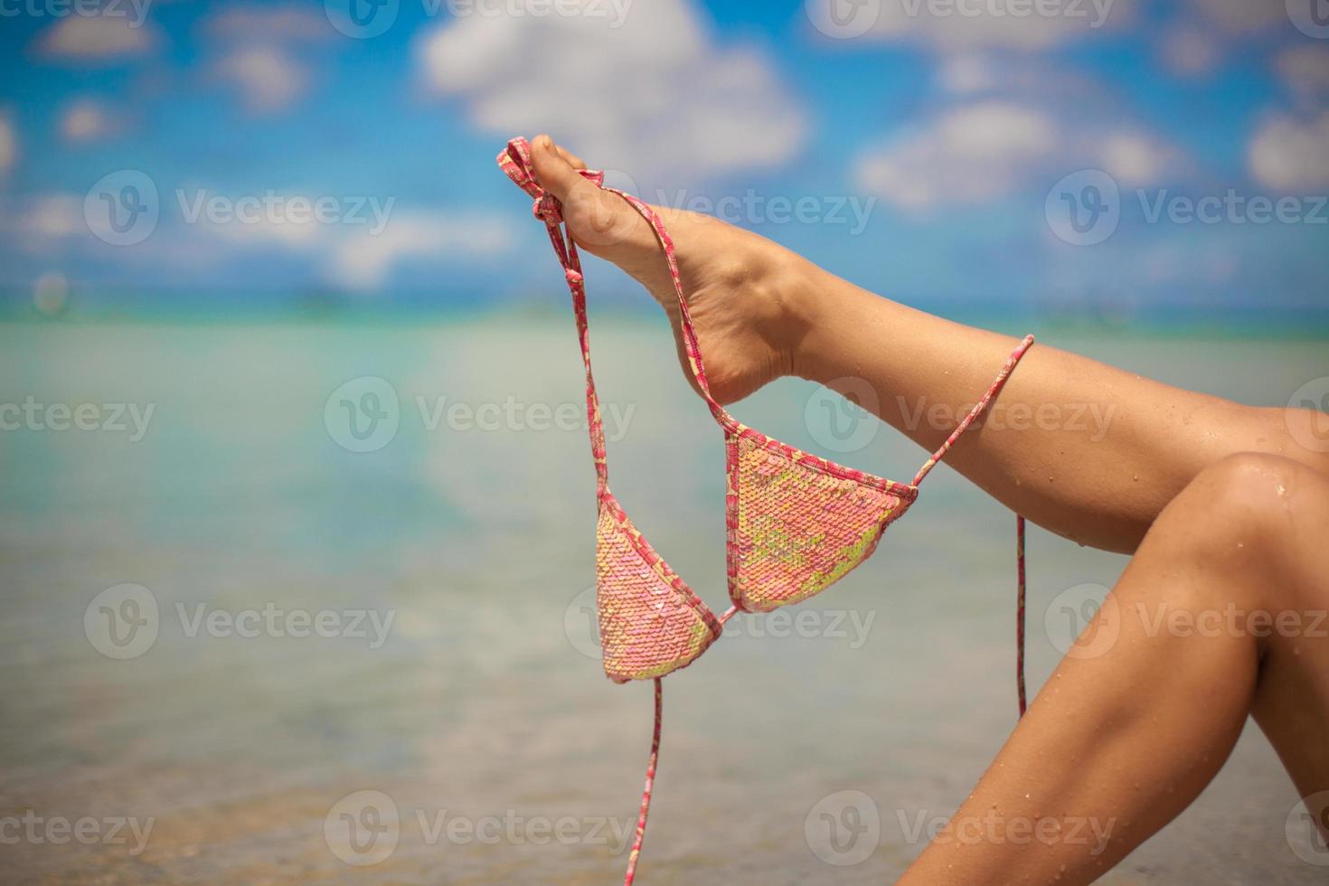 donna gamba Tenere rosa reggiseno isolato su esotico sfondo foto