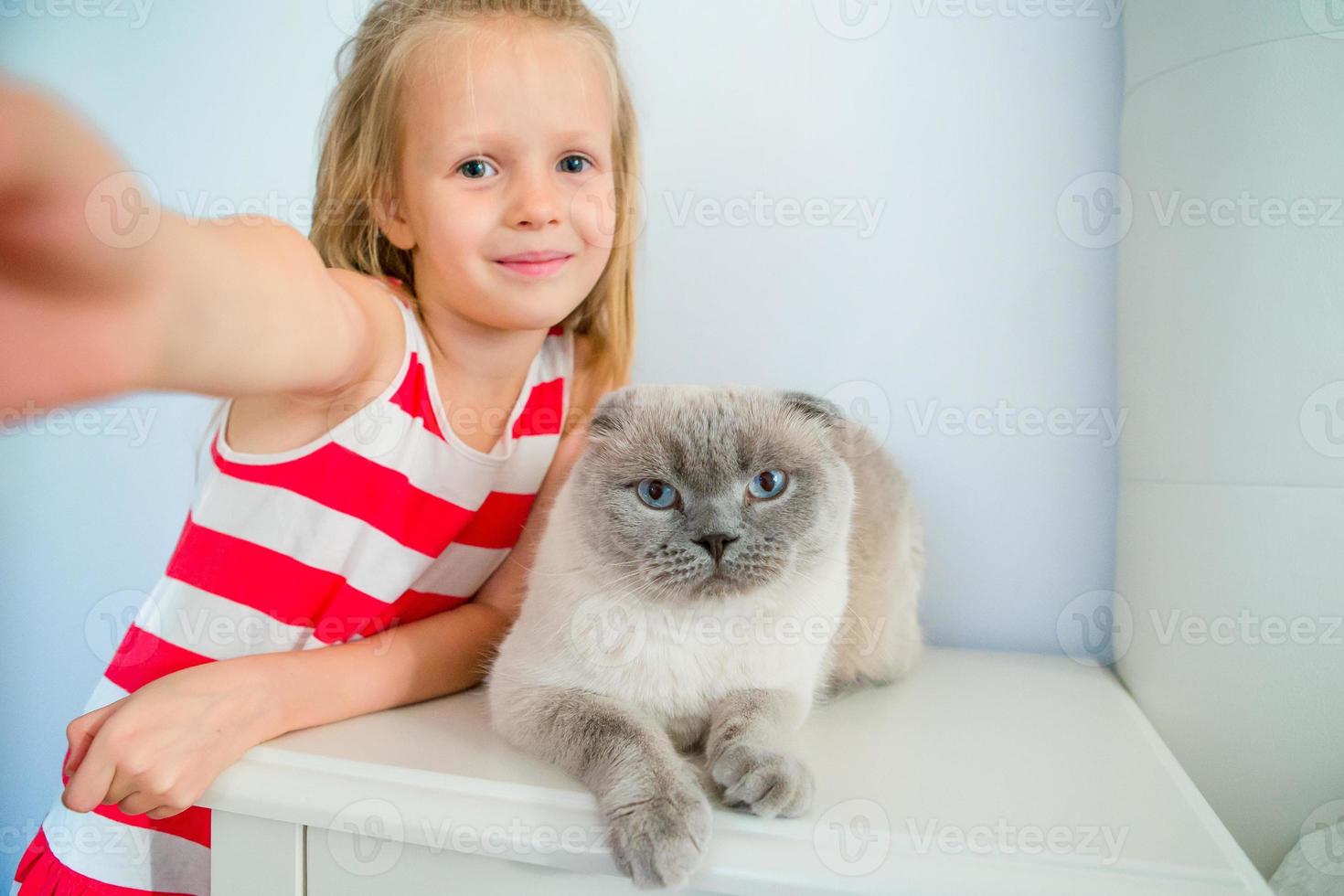 carino poco ragazza baci sua animale domestico gatto a casa. amore fra ragazzo e animale domestico foto