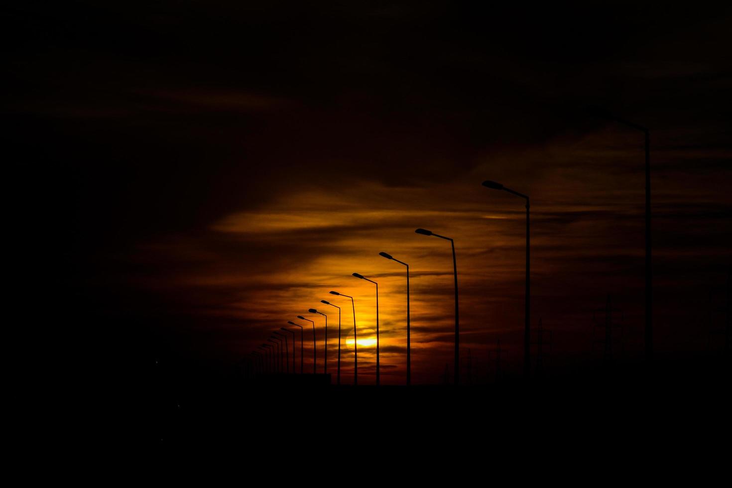 fila di lampioni stagliano durante il tramonto foto