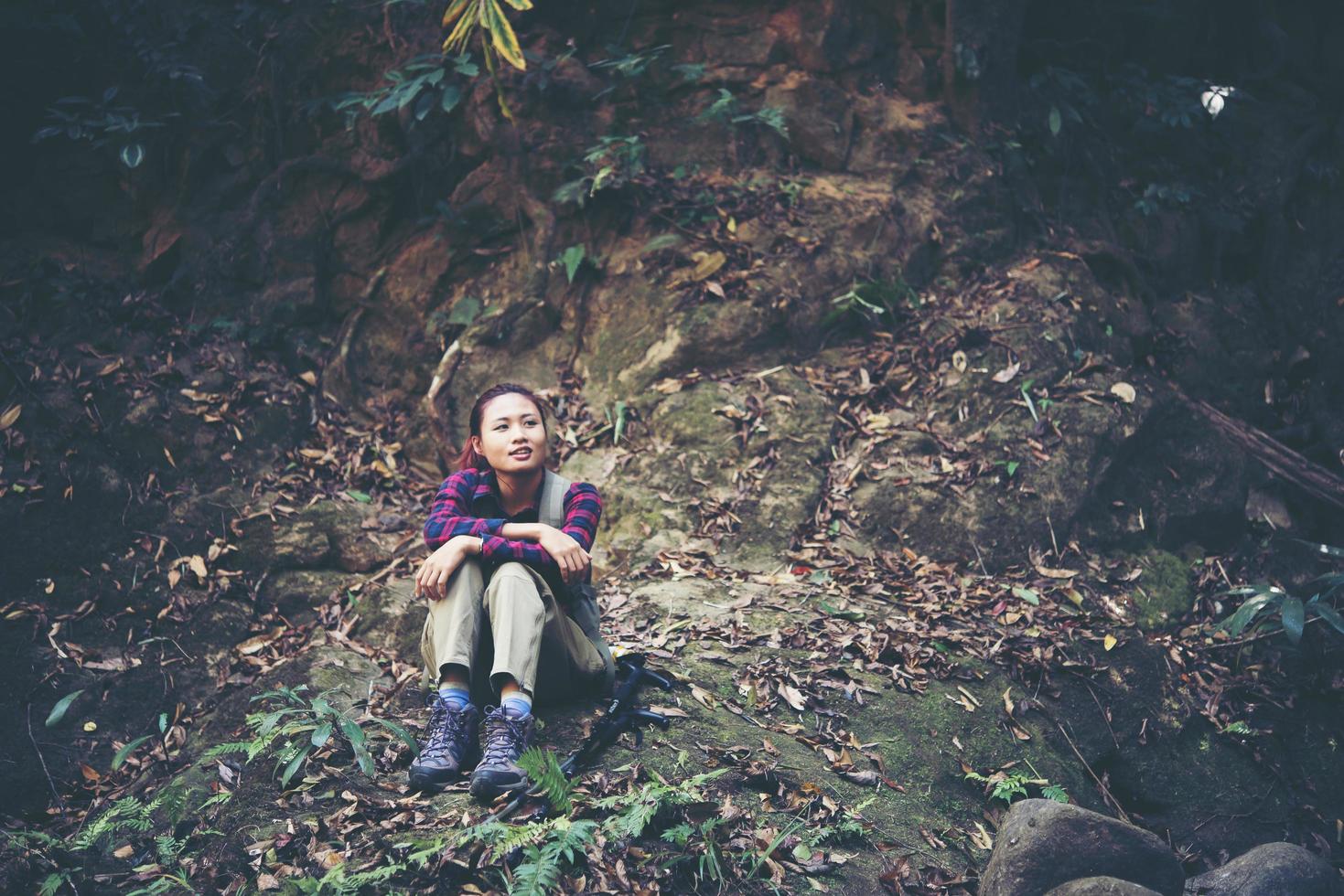 donna escursionista nella foresta prendendo un periodo di riposo foto