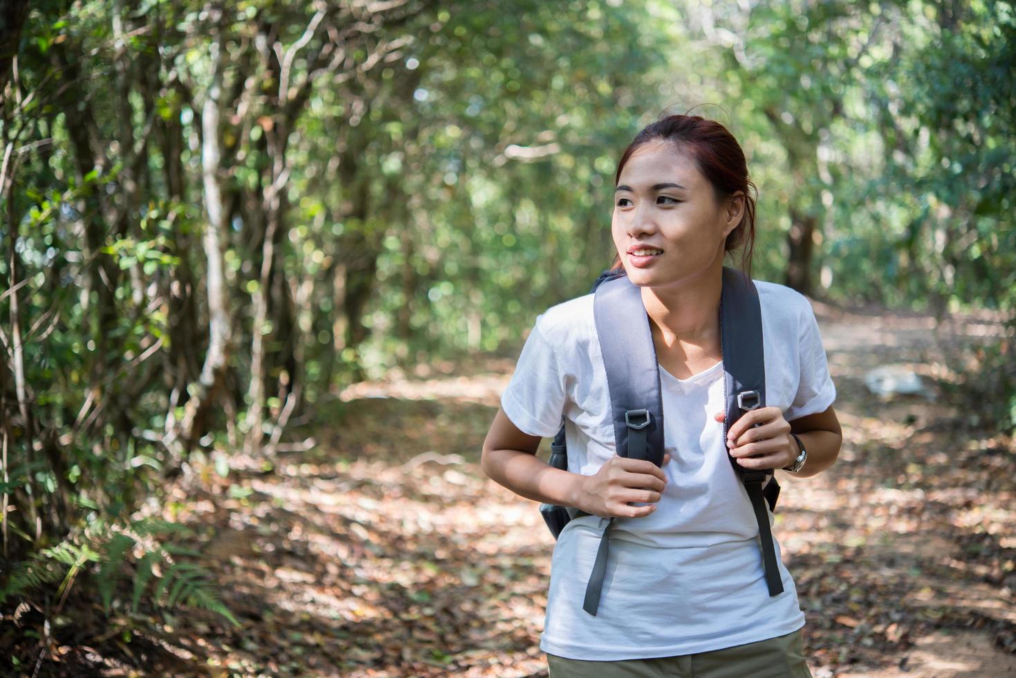 escursionista attivo giovane donna che cammina attraverso la foresta foto