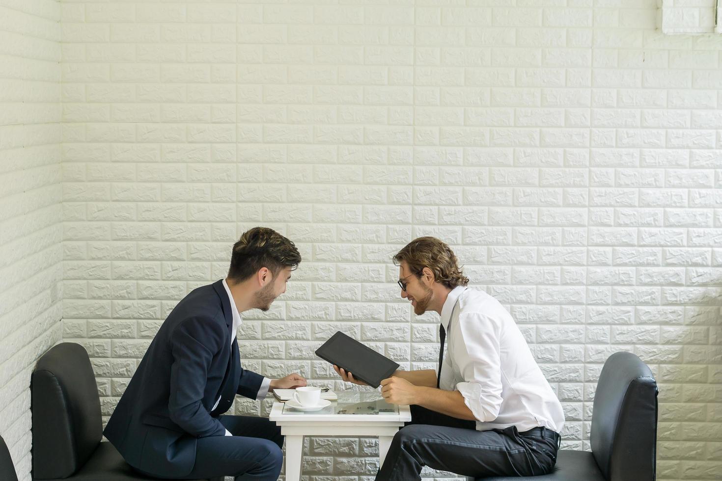 giovane imprenditore parlando con un collega in un moderno business lounge foto