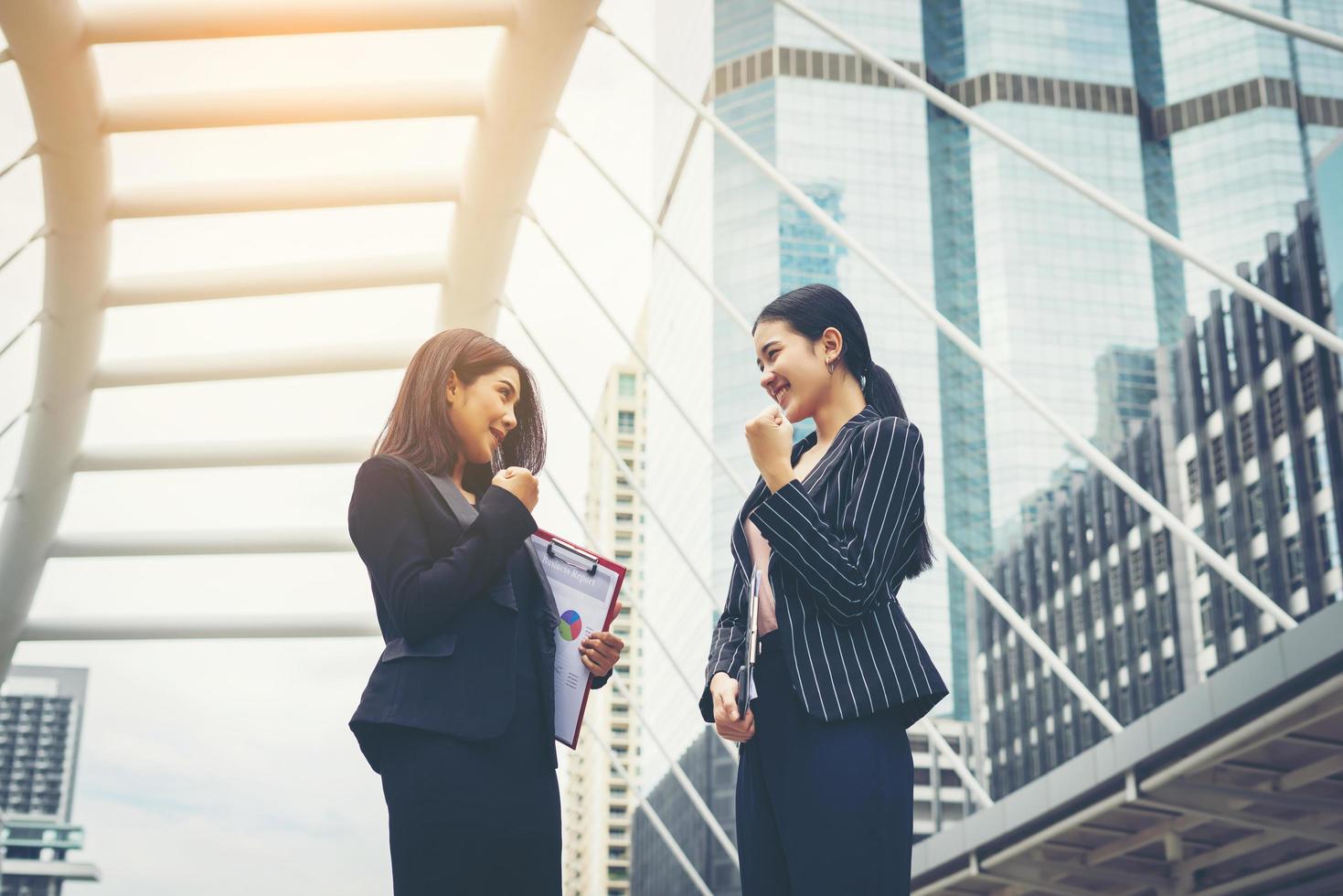 due donne di affari stanno e discutono del lavoro davanti all'ufficio foto