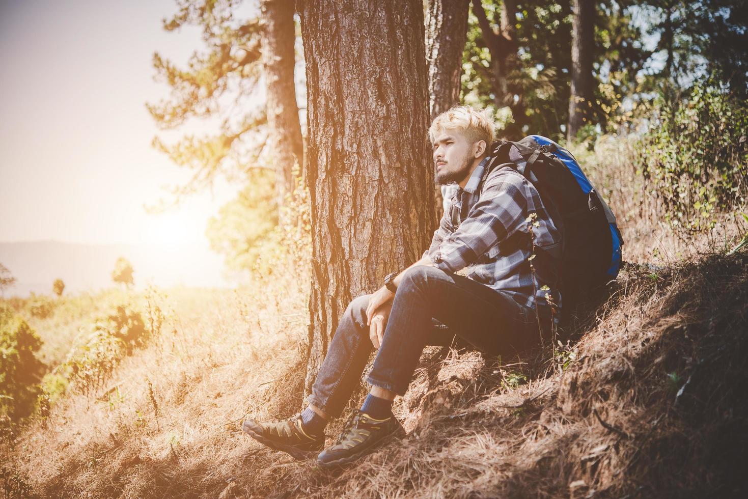 giovane che viaggia con uno zaino in natura foto