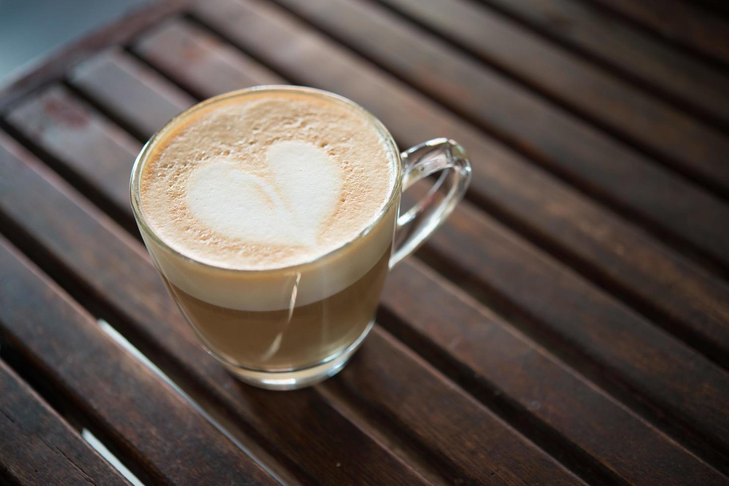 primo piano della tazza del cappuccino con il modello del latte a forma di cuore foto
