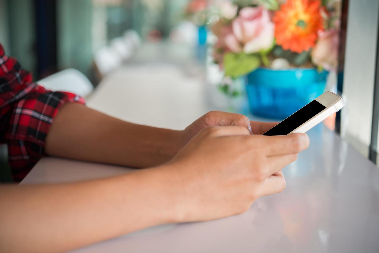 primo piano di una donna che tiene il telefono cellulare e la digitazione foto