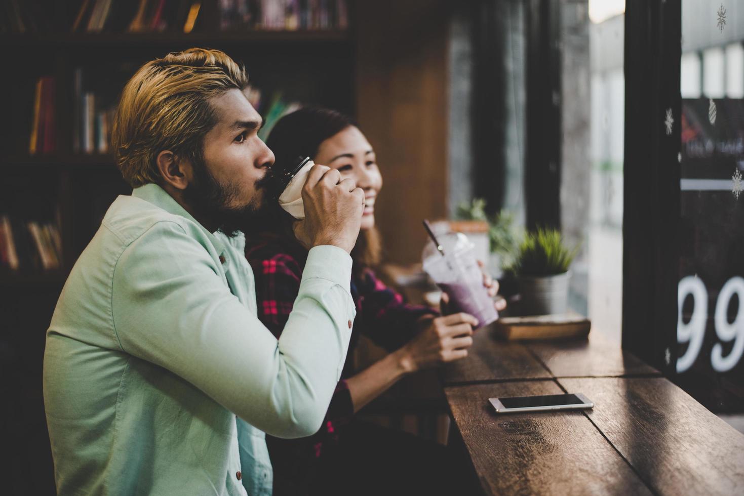 coppia hipster in vacanza seduti in caffè al chiuso bere caffè foto