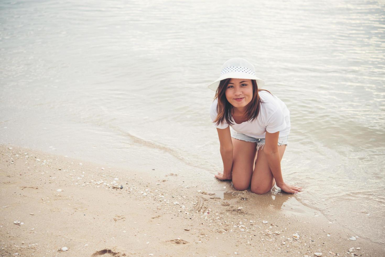 felice giovane donna in vacanza in spiaggia foto