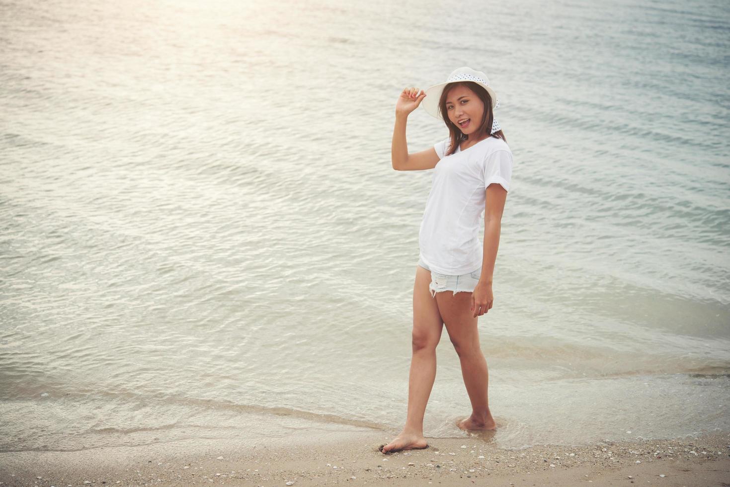 giovane bella donna che si distende sulla spiaggia foto