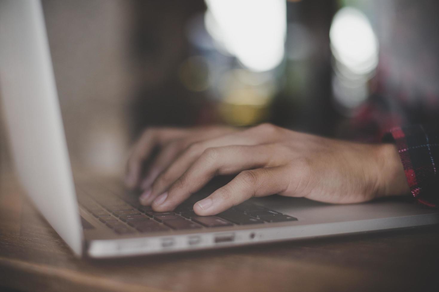 primo piano di una donna che lavora con il suo laptop in un bar foto