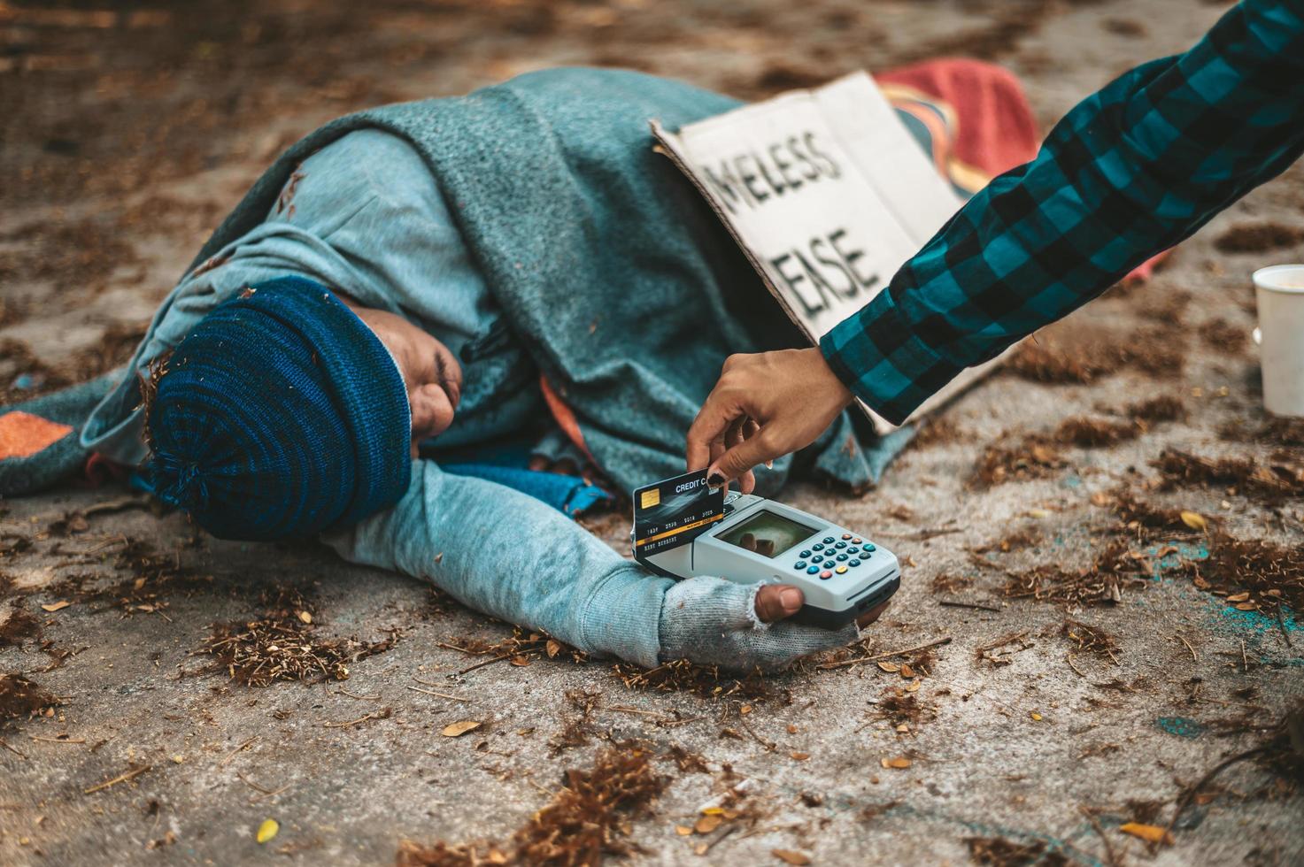 mendicante con una macchina magnetica per carte di credito foto