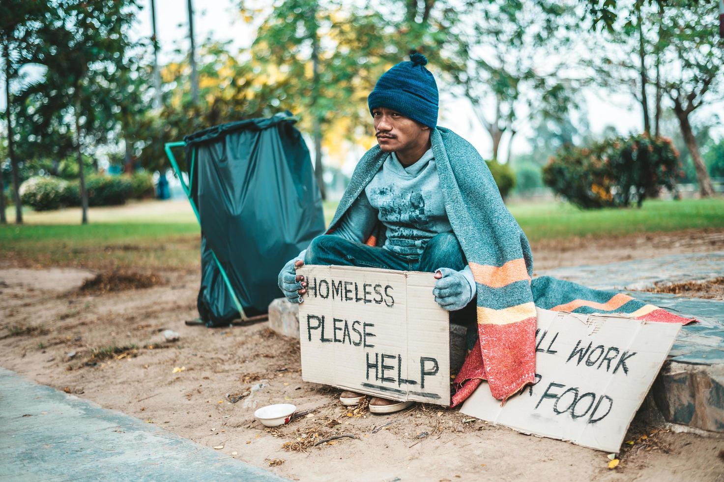 mendicante avvolto in stoffa in strada che accetta denaro foto