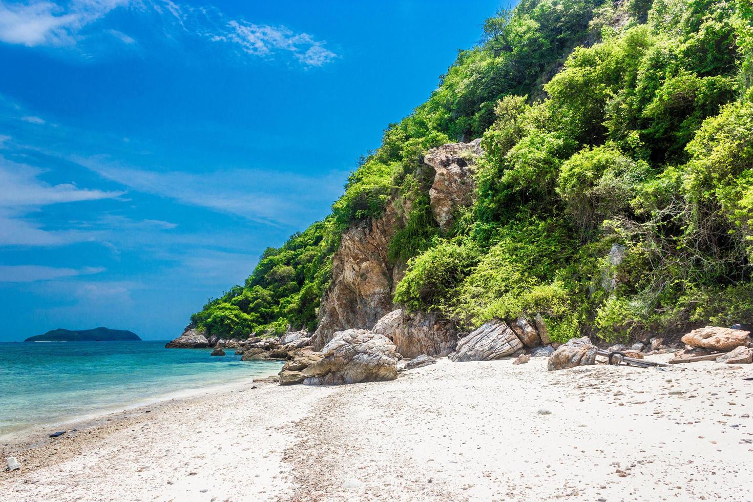 roccia dell'isola tropicale sulla spiaggia con cielo blu nuvoloso foto