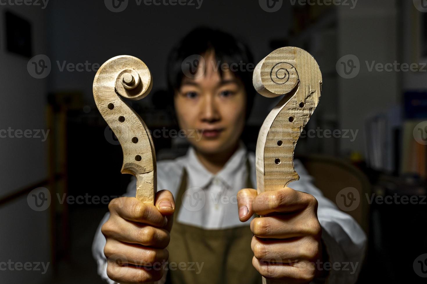 giovane Cinese violino creatore a opera nel sua laboratorio foto