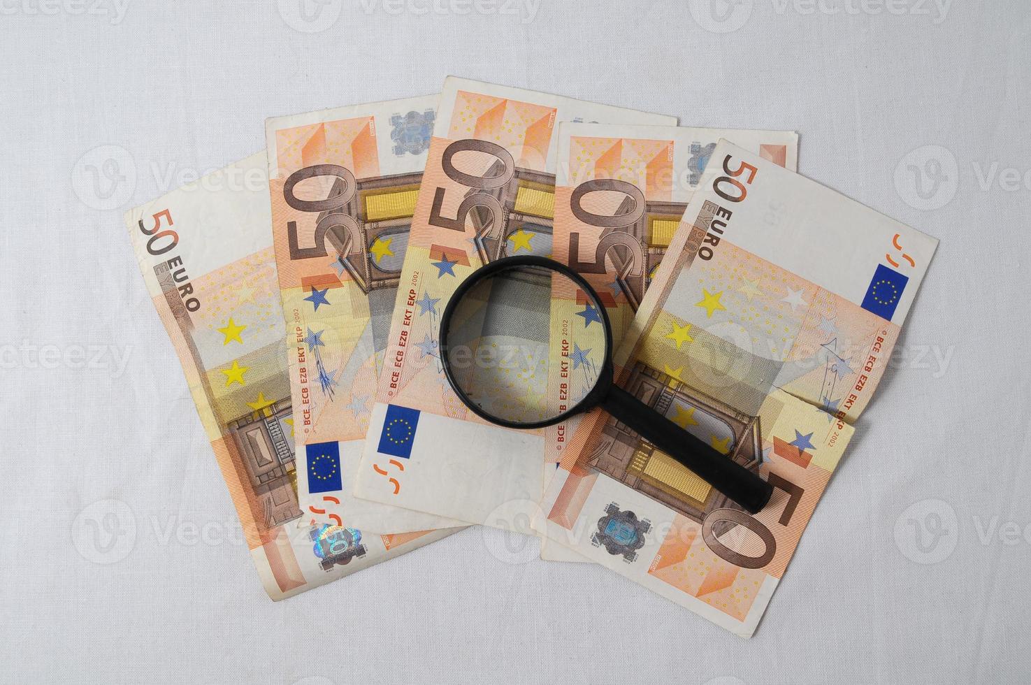 Euro banconote sotto un' ingrandimento bicchiere foto