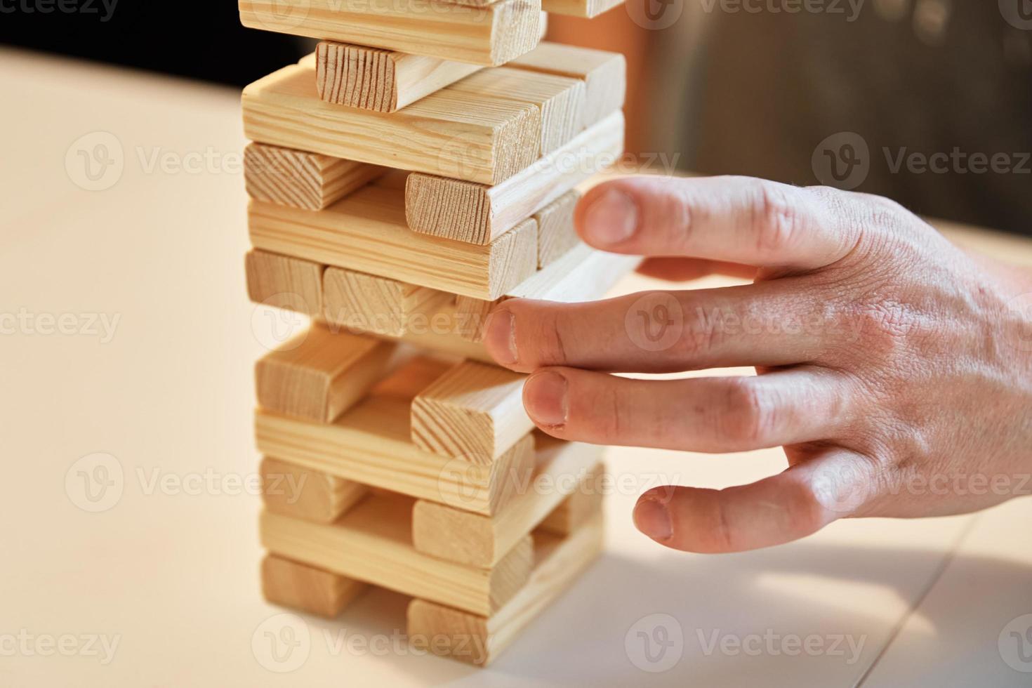 famiglia giocare tavola gioco. mani prendere di legno bloccare a partire dal Torre. foto