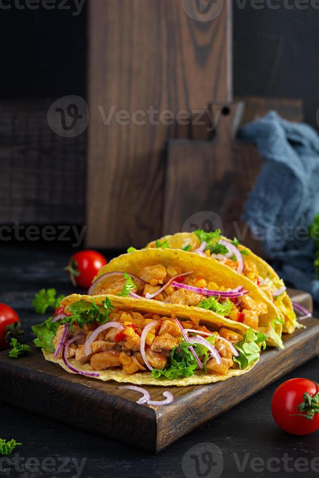 messicano tacos con Mais tortilla. tortilla con pollo carne, Mais, lattuga e cipolla foto