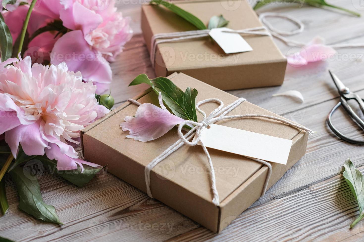 finto su etichetta, kraft regalo scatole decorato con fiori peonie.  preparazione di i regali per La madre di giorno, compleanno, Da donna  vacanza. regalo involucro idea 19571325 Stock Photo su Vecteezy