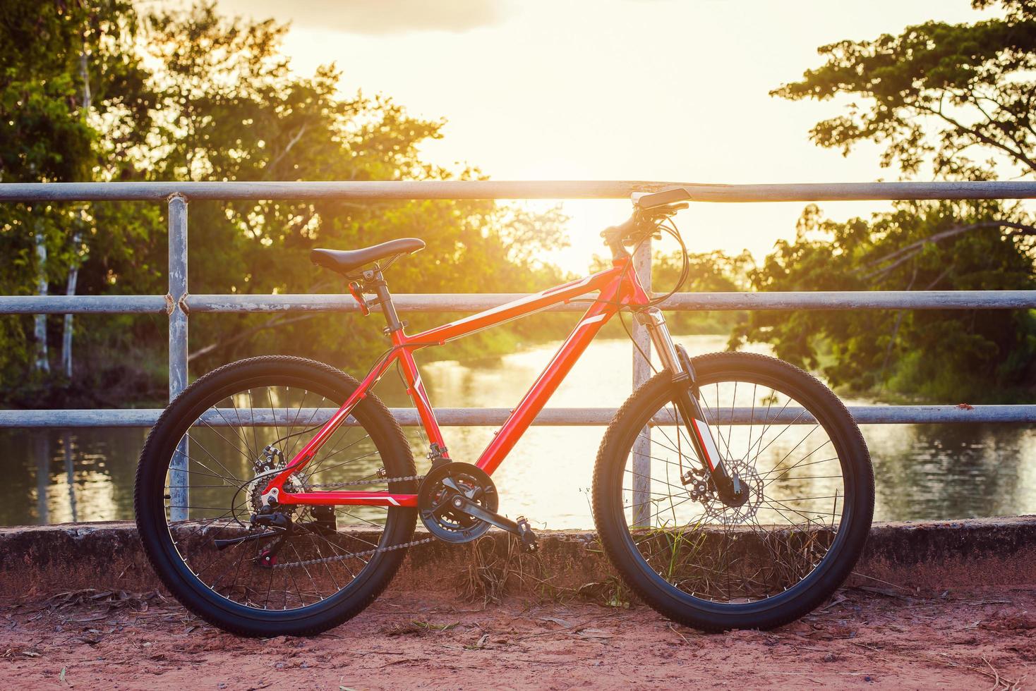 bicicletta parcheggiata fra il modo e tramonto foto